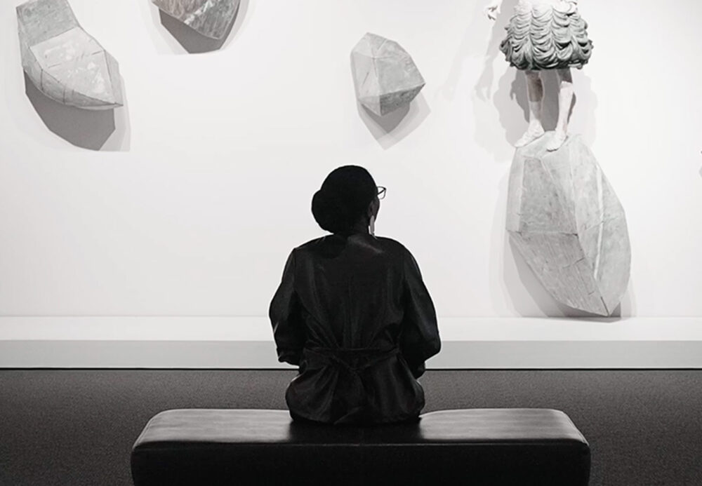 Silhouette of person looking at art