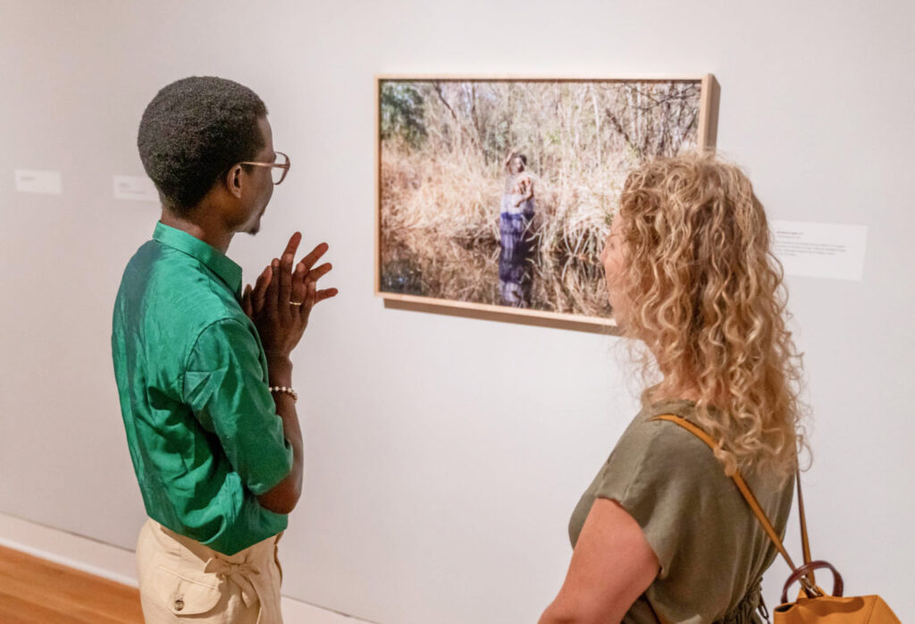Two people talking and looking at art