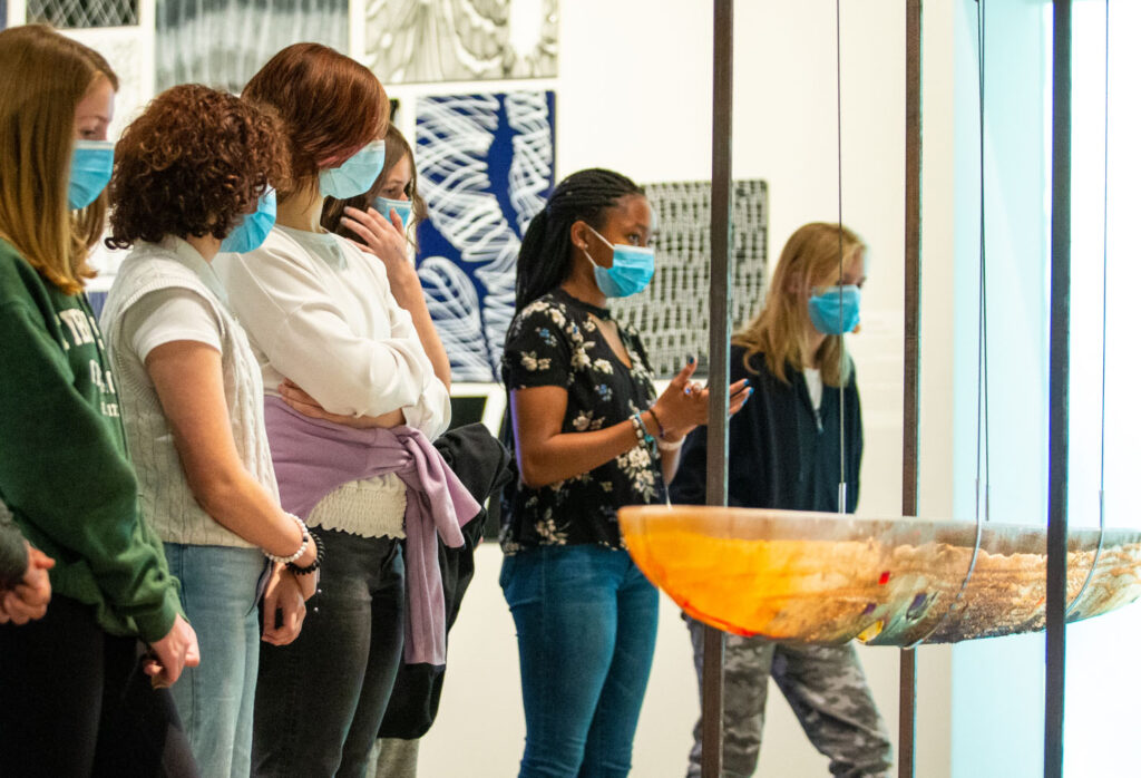 Masked students looking at sculpture