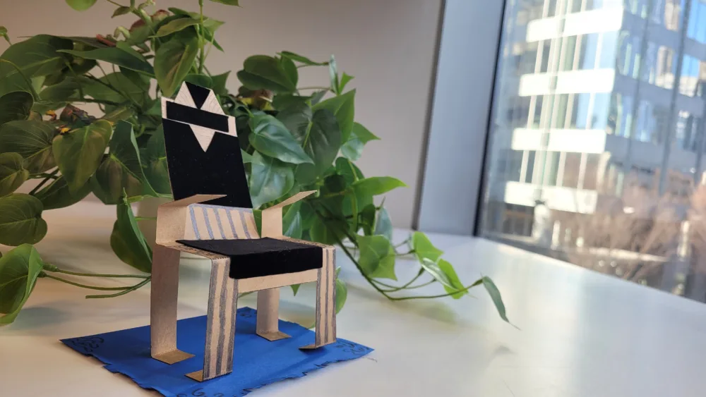 A craft kit chair in front of a plant and window