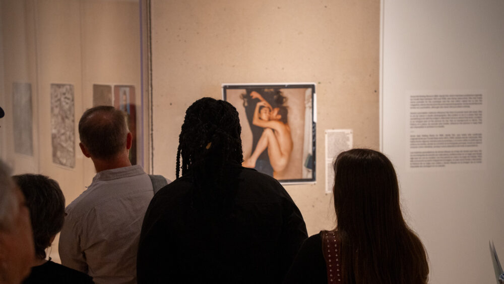 Group of people looking at Yoko Ono and John Lennon photograph in Annie Leibovitz exhibition