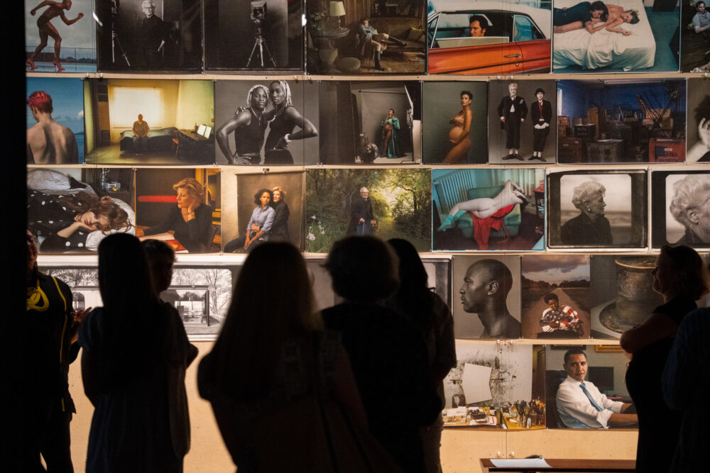 Group of people in front of photo collage wall in Annie Leibovitz exhibition
