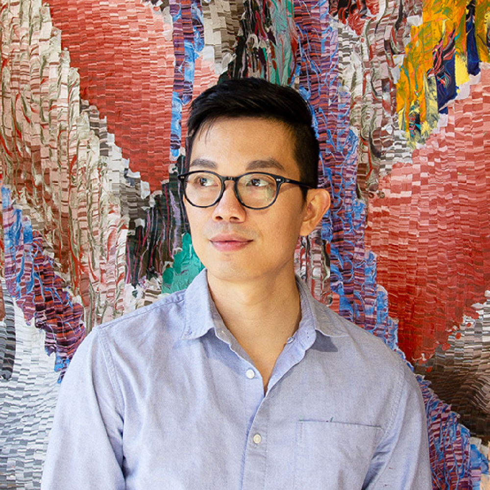 Headshot of Kenny Nguyen in front of artwork