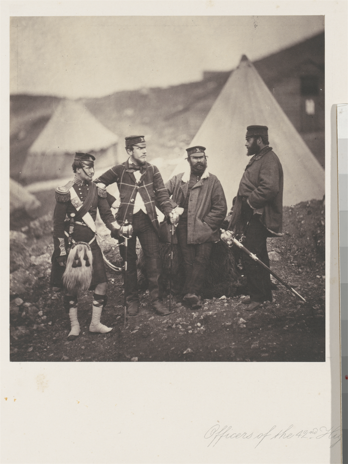 Old photo print of three soldiers in 1856 standing in an emcampment.