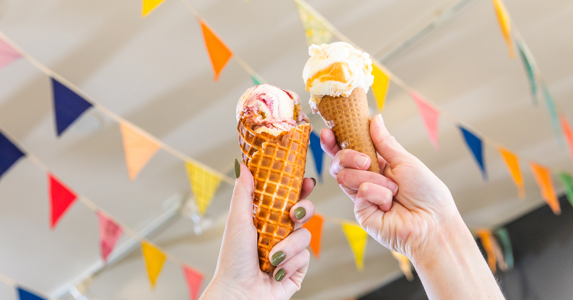 Two hands holding up ice cream cones