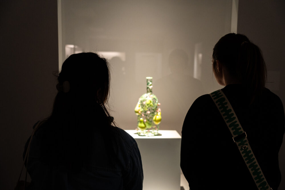 Two people looking at glass art at Mint Museum Randolph
