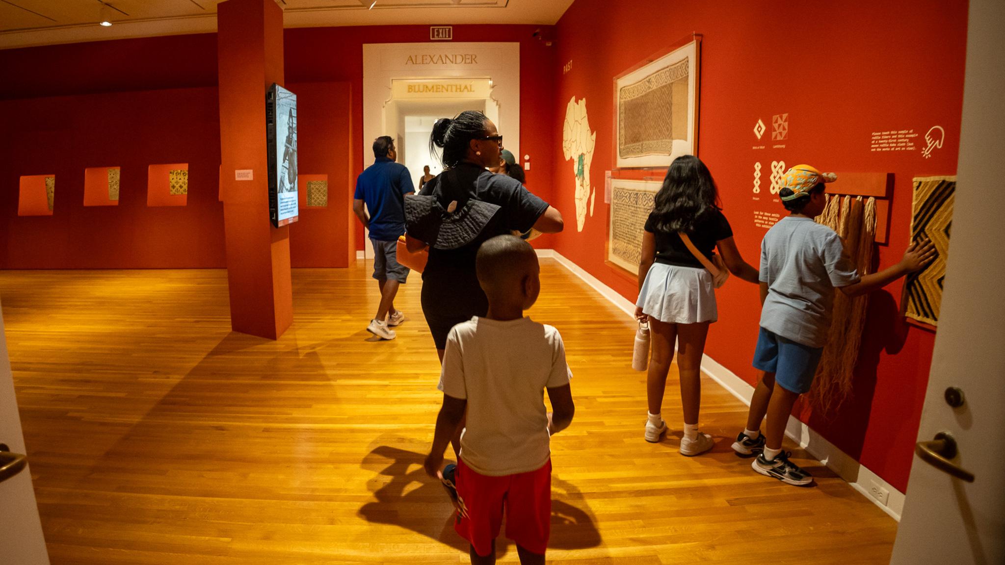 Family looking at art in Designing Dynamism exhibition gallery